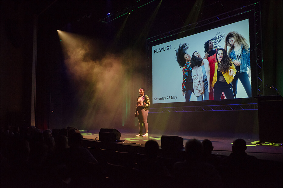 Auditorium stage with performers and projected screen